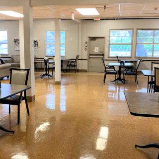 A spacious and bright dining area with tables and chairs arranged for use.