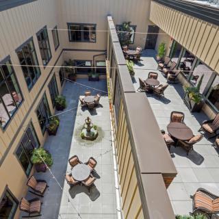 An aerial view of a courtyard with multiple tables and chairs arranged for outdoor seating.