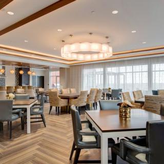 A modern dining area featuring elegant furnishings and a large chandelier.