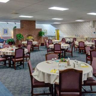 An empty dining room with round tables and chairs neatly arranged.