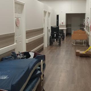 A hallway in a hospital featuring medical beds and equipment.
