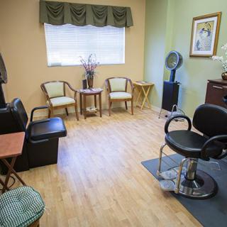 A cozy hair salon featuring a styling chair, mirrors, and waiting area.