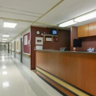 A view of a hospital reception desk and hallway.