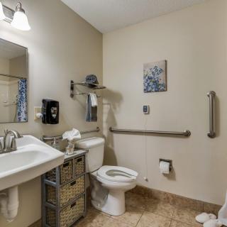 A well-organized bathroom with a sink, toilet, mirror, and storage baskets.