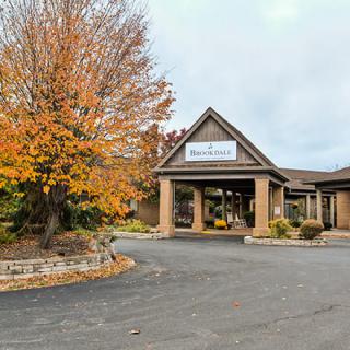 A building with an entrance surrounded by autumn trees.
