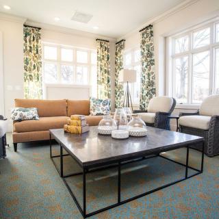 A cozy living room with contemporary furniture and large windows.