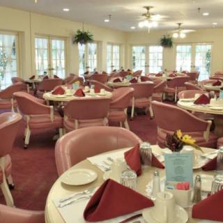 A well-arranged dining room with tables set for a formal event.