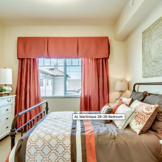 A cozy bedroom with warm decor and elegant curtains.