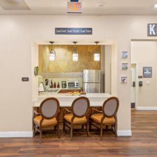 A modern kitchen interior with a seating area featuring three chairs at the counter.