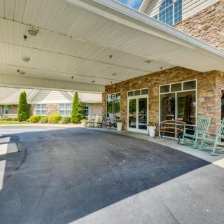 The image shows the exterior entrance of a building with a covered driveway and brick facade.