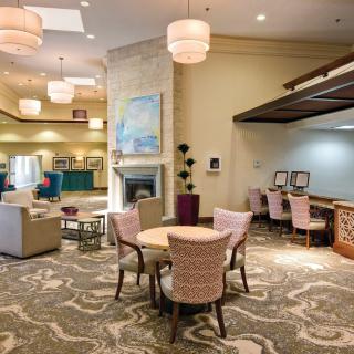A cozy and elegantly decorated lounge area featuring comfortable seating, tables, and ambient lighting.
