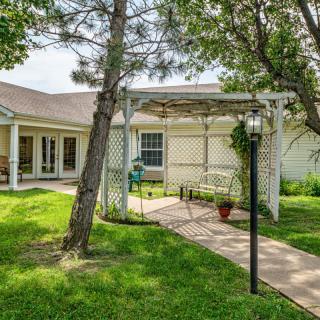 A cozy backyard with a pergola and well-maintained lawn.