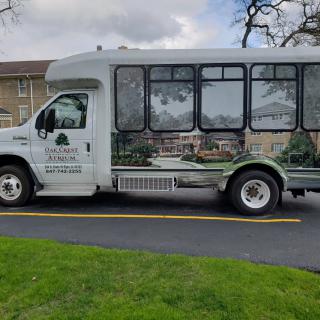 A shuttle bus parked on the side of a road on a cloudy day.