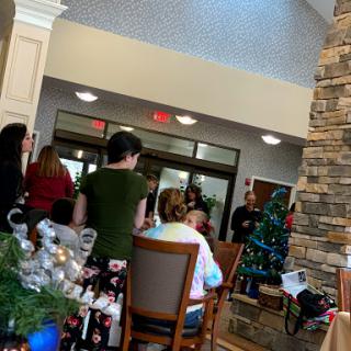 A festive gathering during the holiday season, featuring a decorated Christmas tree and cheerful attendees.