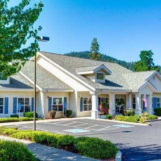A picturesque residential building with a well-maintained landscape and clear blue sky.