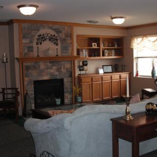 A cozy living room with a fireplace, built-in shelves, and comfortable seating.