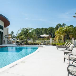 A serene outdoor pool area featuring comfortable lounge chairs and a sunny atmosphere.