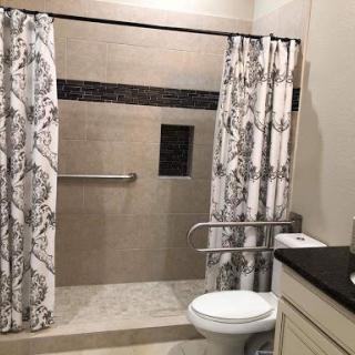 A well-designed bathroom featuring a modern shower and elegant curtains.