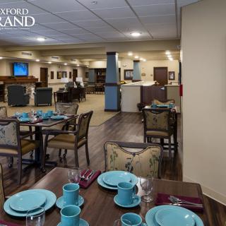 A cozy dining room setup with tables and chairs, elegantly arranged with blue tableware, creating a welcoming restaurant ambiance.