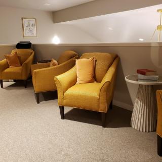 A modern seating area with yellow armchairs and a small side table.