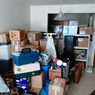 A packed room filled with various boxes and items, indicating preparation for moving or storage.