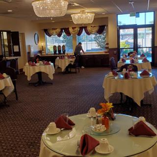 A beautifully arranged dining area in a restaurant, featuring elegant tables and chandeliers.
