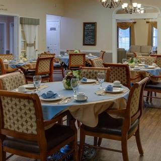 A cozy dining room with elegantly set tables and comfortable chairs.