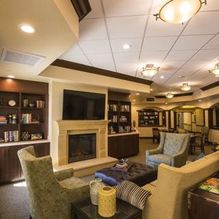A cozy living room with comfortable seating, a fireplace, and a television.