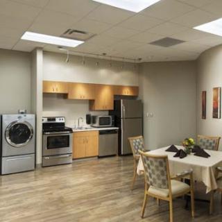 A modern kitchen and dining area featuring various appliances, a dining table, and comfortable seating.