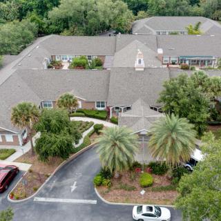 Aerial view of a residential building complex surrounded by trees and greenery.