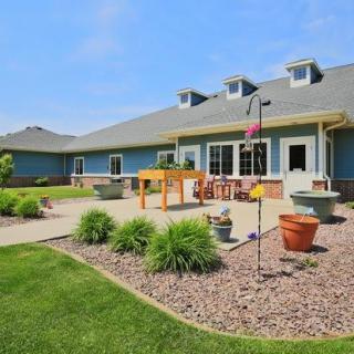 A well-maintained outdoor area with a patio, garden landscaping, and a modern building in the background.