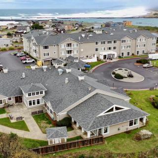 An aerial view of a coastal community featuring large residential buildings near the ocean.