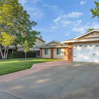 A suburban house with a driveway and well-maintained lawn.