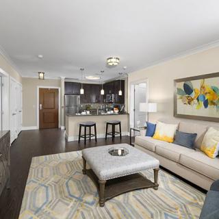 A modern open-concept living room with stylish decor and a connected kitchen area.