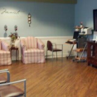 A cozy waiting room with various chairs, a television, and decorative elements.