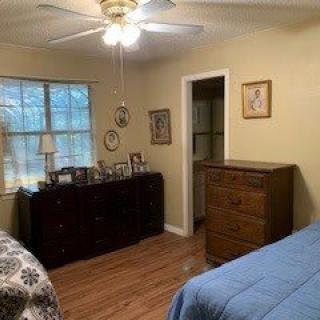 A cozy bedroom with wooden furniture and a ceiling fan.
