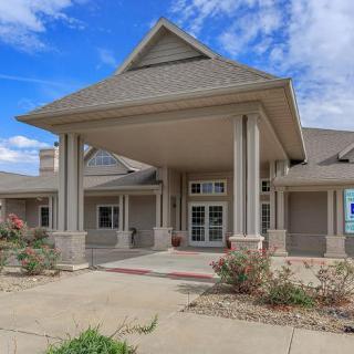 A residential building with a prominent entrance and columns under a clear blue sky.