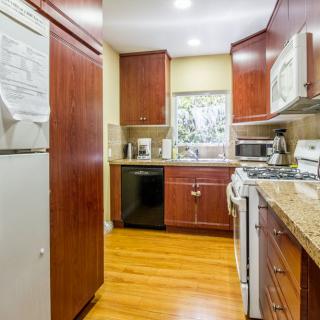 A modern kitchen with wooden cabinets and a hardwood floor.