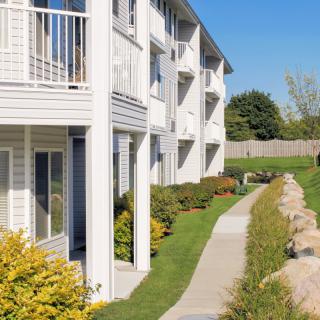 A sunny day at a residential apartment complex with well-maintained landscaping and a walking path.
