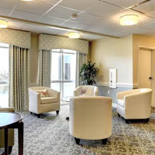 A cozy lounge area featuring comfortable chairs and large windows, perfect for relaxation.