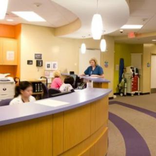 A hospital reception area with nurses working at the desks.