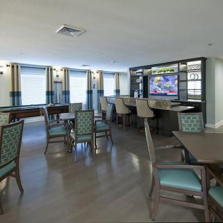 A modern dining and bar area with comfortable seating and a television.