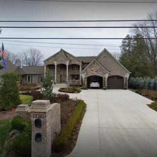 A modern residential house with a well-maintained garden and driveway.