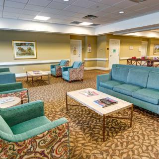A well-furnished lobby area with sofas and chairs arranged around coffee tables.