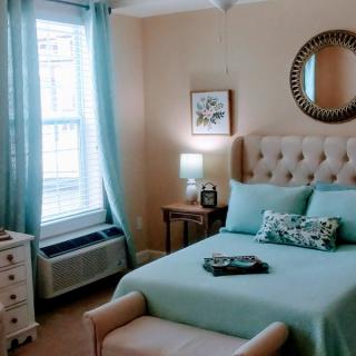 A cozy bedroom with turquoise decor and ample natural light.