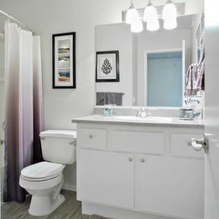 A modern bathroom featuring a sleek sink, contemporary lighting, and a stylish shower curtain.