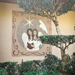 A beautiful mural depicting two angels under a star, surrounded by lush greenery.