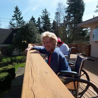 People enjoying a sunny day on the deck in wheelchairs.