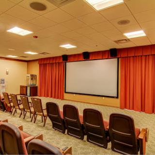 A spacious screening room equipped with comfortable seating and a large projection screen.