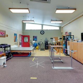 A spacious therapy room equipped with various rehabilitation tools and resources.